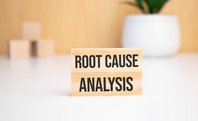 On a light background, wooden cubes and a wooden block with the text Root Cause Analysis. View from above