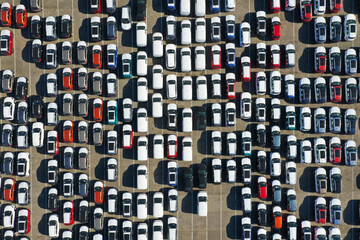 Obraz premium Aerial view from drone to automobile customs terminal. Large number of cars at customs terminal are awaiting shipment. Accumulative customs platform for cars.