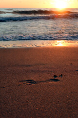 Scenic sunset over the sea. Footprint in the sand. Calm Baltic sea. Poland seaside,  Dabki village and beach. Seascape. 