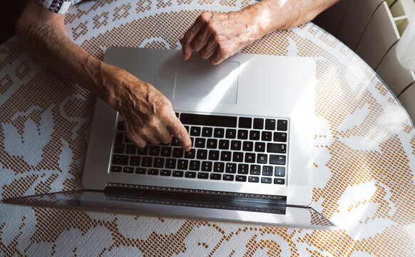 Elderly Woman Typing On Laptop At Home