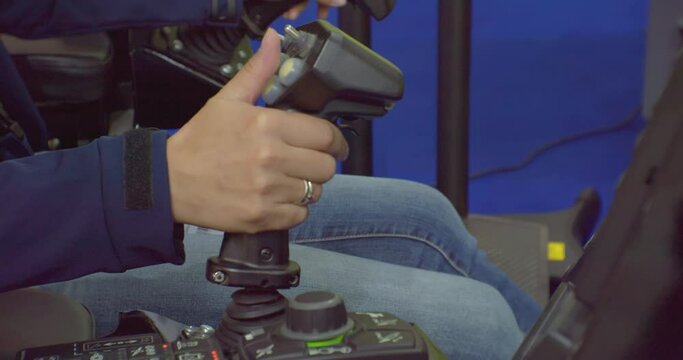 Close-up, the driver controls the car with the joystick.The worker presses the joystick buttons while driving the machine.