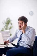 Young male employee and too much work in the office