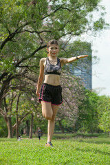 Asian woman warming up before running in the park
