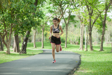 Asian woman warming up before running in the park