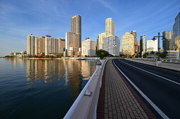 Naklejka premium Brickell Key Bridge and City of Miami skyline at sunrise under clear blue sky om tranquil summer morning.