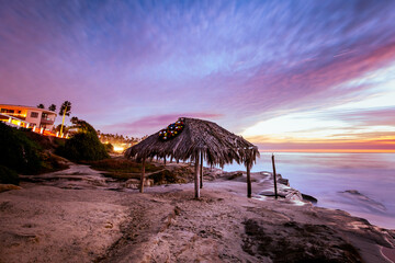 Holiday Christmas wreath on a thatched hut in San Diego California with a colorful sunset over the...