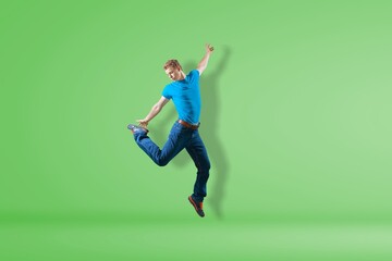 Young cool millennial male jump on the color background