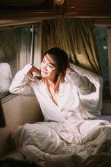 Obraz premium Beautiful young woman in a white shirt in the bedroom at home