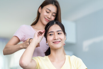 Fototapeta na wymiar Asian beautiful lesbian women couple combing girlfriends hair in house