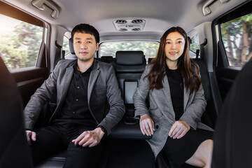 two business man and woman sitting at the back seat of car