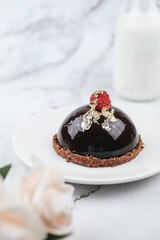 Chocolate mousse Cake with berries with rose flower on marble table. Delicious homemade cake.