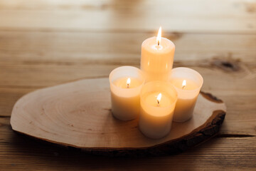 Obraz na płótnie Canvas Warm candles on a wooden table. Autumnal decoration