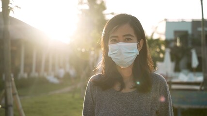 Coronavirus. Asian woman putting on a medical disposable mask to avoid viruses.