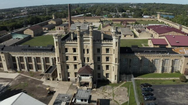 Aerial view of the derelict and abandoned Joliet prison or jail, a historic place. Drone moving towards front gate tower taking aerial shot and coming down to capture view of front gate.
