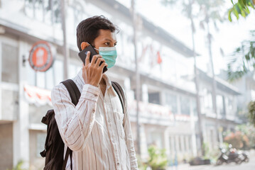 student wearing face mask before going to school or campus