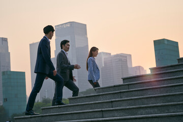 team of asian corporate executives walking in central business district