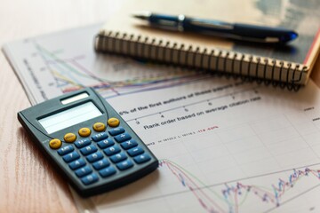 Calculator, Pen and Business Charts