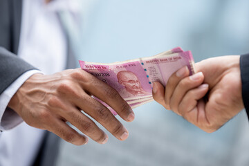 Businessman hand giving money Indian rupee currency to partner, loan and bribery concepts
