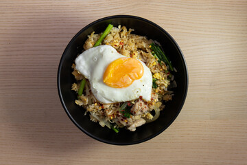 A bowl of fried rice with fried egg on top.