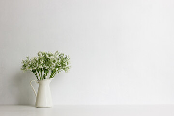 A bouquet of white flowers in vase with nature light.