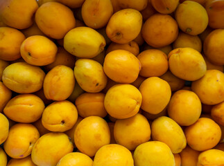photo of a lot of apricots on the counter of the store