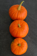 New autumn harvest bright orange pumpkins on text dark background