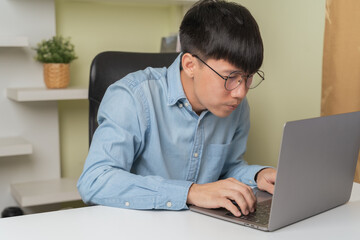 Stressed young Asian businessman, man looking, gazing computer laptop  when dizziness, blurry vision on overworked, studying, learning about business money investment. Stressed businessman concept.