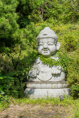 Stone carved seated buddha n grove of trees