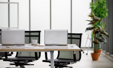 Blank black screen monitor laptop notebook computer for copy space text on working table full of business plan graph chart diagram paperwork report target documents and white coffee cups in office