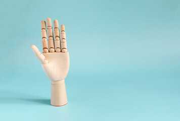 A wooden hand with an open palm. The concept of an artificial hand on a colored background.