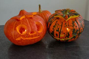 Halloween carved bright orange pumpkin jack lantern with different expressions of immotions on dark textured background