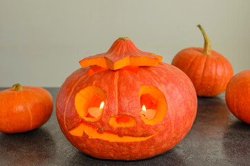 Halloween carved bright orange pumpkin jack lantern with different expressions of immotions on dark textured background