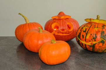 Halloween carved bright orange pumpkin jack lantern with different expressions of immotions on dark textured background