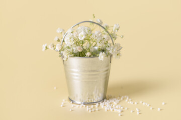 Metal bucket with beautiful flowers on color background