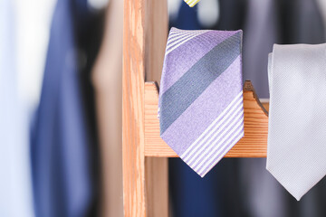 Wooden stand with different stylish neckties, closeup