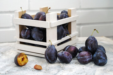 harvest of ripe juicy plums on the table and in a wooden box