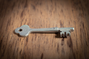 old rusty key on wooden background 