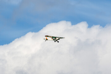 Small engine airplane flying among the clouds