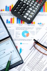 Obraz premium Calculator, Pen and Checkbook on Business Graphs