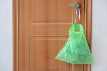 Bag with garbage hanging on door knob