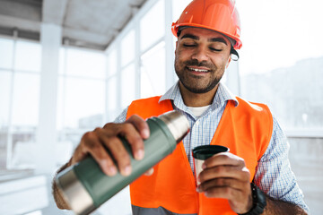 Portrait of a man worker in workwear on a break drink coffee and have rest