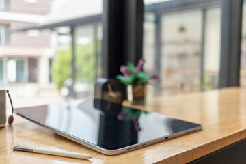 blurred photo,laptop and document placed on the office desk window to save energy as it uses natural light to help work during the day and make business people happy to work and talk business.