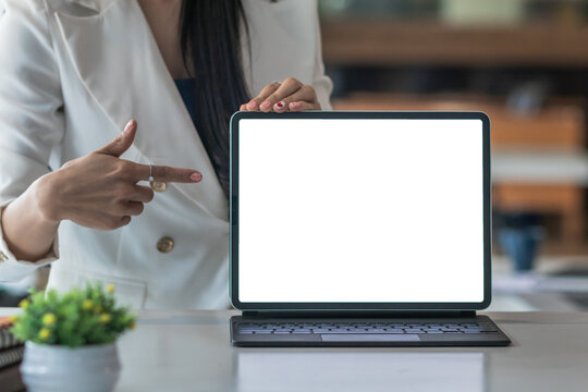 The businesswoman presents her plans on a tablet screen in the meeting and the businesswoman can also share the information via the Internet in the office with the attendees.