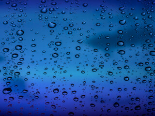 Water droplets texture on blue glass as a background