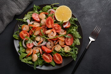 Fresh salad plate with shrimps, onions, lemon, tomatoes and mixed greens (arugula, mesclun, )
