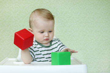 Defocused baby plays logical toys. Geometric figures. Copy space - concept of early development, intelligence, fun games, mind, skill acquisition, education, family learning activities at home