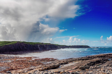 Spanish point in county Clare, Ireland. Rough stone coast line, blue cloudy sky and water of...
