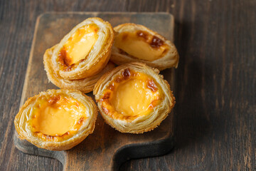 Pasteis de Belem,  portuguese egg tart pastries  on wooden cut board. Copy space