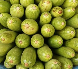 Close up shot of many bottle gourds placed over one another. Green wall paper of close up shot of  green bottle gourds placed side by side.