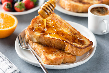 Pouring honey on french toast. Sweet breakfast food - 459626351